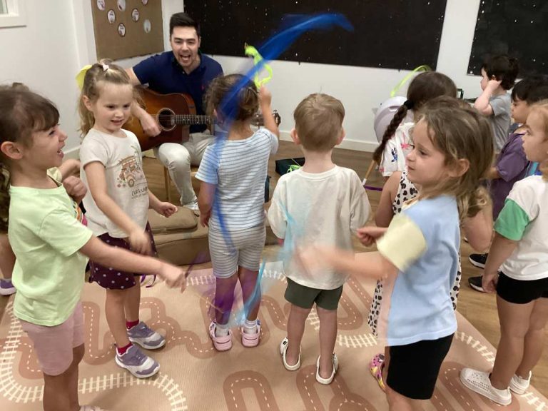 Children dancing with ribbons during a music session at Macarthur Early Learning