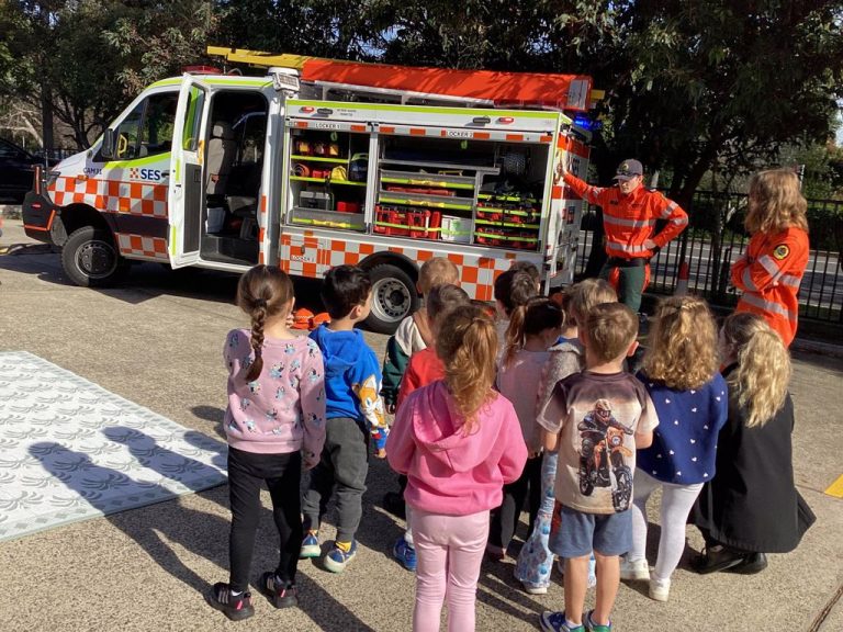 Children gathered around an SES truck during a community visit at Macarthur Early Learning